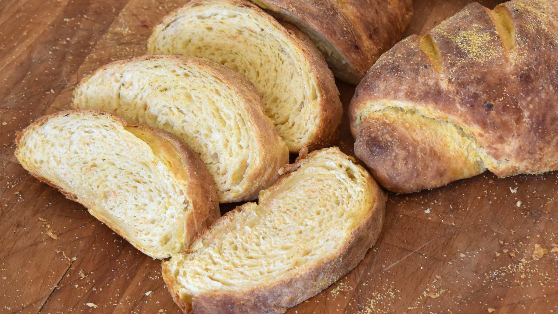 Kruh s mrkvom i krumpirom nakon pečenja narezan na šnite slikano u kuhinji na stolu
